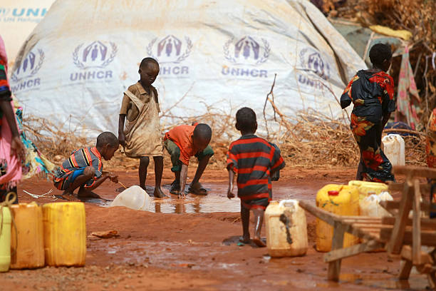 Famine in Africa Dadaab Refugee Camp Dadaab , Kenya - August 14, 2011: Somalian children refugees fetch water at the new Ifo-extension in Dadaab on August 14, 2011. The new site opened to some 5,000 refugees among an ever swelling number of Somalia's people coming into the Dadaab refugee complex in Kenya's north-easterly province. The Ifo extension, which will provide tented accommodation to 90,000 refugees by the end of November, had been prepared several weeks ago but its opening was delayed owing to opposition from Kenyan government ranks citing a threat to the national security. african tribal culture photos stock pictures, royalty-free photos & images