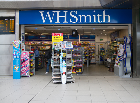 Sheffield,Yorkshire, UK - May 10th 2013:  WHSmith  shop at Sheffield railway station selling  books, stationery, magazines, newspapers, and entertainment products a customer and store assistant seen inside.