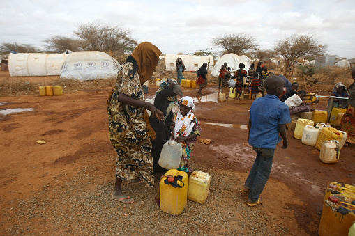 Dadaab , Kenya - August 14, 2011: Somalian children refugees fetch water at the new Ifo-extension in Dadaab on August 14, 2011. The new site opened to some 5,000 refugees among an ever swelling number of Somalia's people coming into the Dadaab refugee complex in Kenya's north-easterly province. The Ifo extension, which will provide tented accommodation to 90,000 refugees by the end of November, had been prepared several weeks ago but its opening was delayed owing to opposition from Kenyan government ranks citing a threat to the national security.