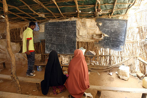 Education in Dadaab Refugee Camp Daadab, Kenya - August 14, 2011:  Somali girls study English in Dadaab, the worlds biggest refugee camp August 14, 2009 in Dadaab, Kenya. The Dadaab refugee complex in northeastern Kenya consists of three separate camps and has been in operation for 18 years and is currently home to some 289,500 inhabitants. Most of the residents of the camps are Somalis who are fleeing escalating violence in that country. Dadaab currently holds three times as many people as it was designed for with 43,000 refugees arriving from Somalia this year alone. Concerned over the deteriorating situation in Dadaab, the Kenyan government has recently begun moving some refugees to another camp which is a three day bus ride away. unicef photos stock pictures, royalty-free photos & images