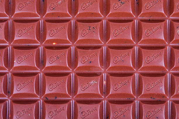 Large Bar Of Cadbury Fruit And Nut Chocolate Helston, Cornwall, UK - May 9, 2013: A large bar of Cadbury Dairy Milk Fruit And Nut Chocolate with the Cadbury logo on each piece. cadbury plc photos stock pictures, royalty-free photos & images
