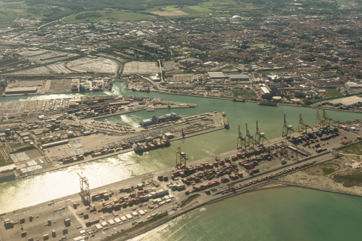 Livorno, Italy - May 13, 2013: Livorno coastline aerial view form the porthole of an airplane. Is visible the industrial harbor . Clear sky on early morning. livorno is a city on tuscany, central italy.