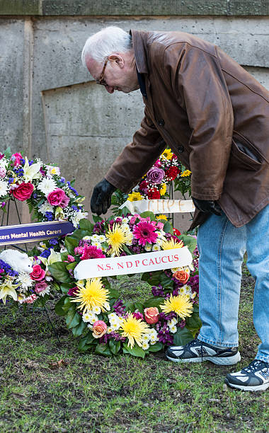 NDP MLA lays wreath Halifax, Canada - April 28, 2013: Howard Epstein, NDP MLA for Halifax-Chebucto, lays a wreath outside Province House during a public Day of Mourning service.  The National Day of Mourning is observed in Canada on April 28th. It commemorates workers who have been killed, injured or suffered illness due to workplace related hazards and incidents. ndp stock pictures, royalty-free photos & images