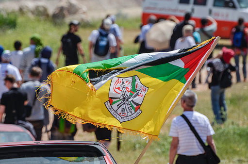 Bilin, West Bank, Israel ‐ April 6, 2012: The flag of the Fatah is waved out of a car window during a rally of protesters. The protest are held every friday near Bilin in the \