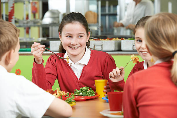 istock Group Of Pupils Sitting At Table In School Cafeteria 471524230