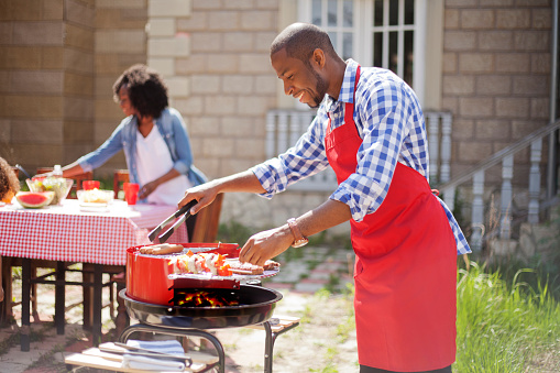 African decent couple make barbecue at their back yard