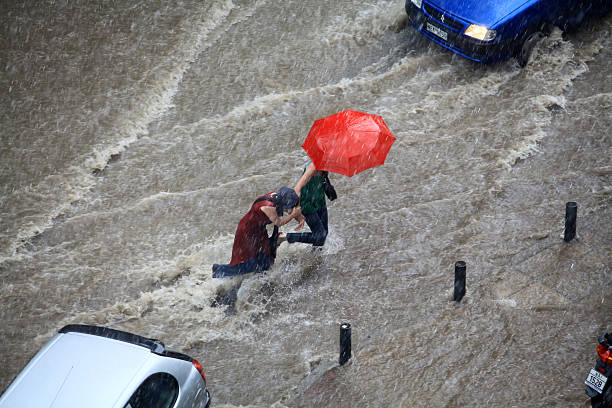 Thessaloniki, Greece - June 15, 2011: People try to cross a flooded road in the center of city. The summer months are a common phenomenon reason for the poor maintenance of drains
