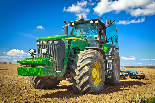 Stargard, Poland - April 28, 2013: John Deere  heavy tractor during cultivation agriculture works at field with plough