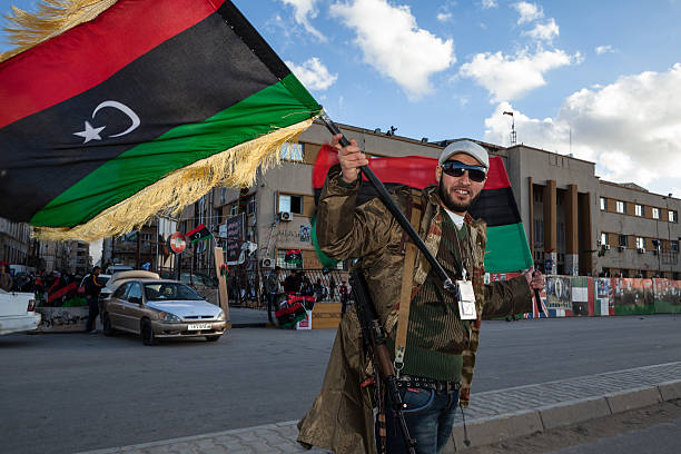 rebel mit einer flagge und kalashnikov - libya arab spring benghazi war stock-fotos und bilder