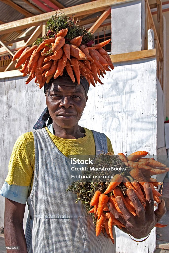 Portrait of a Carrot Seller Jacmel, Haiti - January 13, 2009: Woman selling her carrots in the streets of Jacmel. Adult Stock Photo