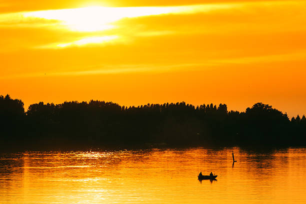 Fisherman on a Boat at Sunset colorful sky and reflection