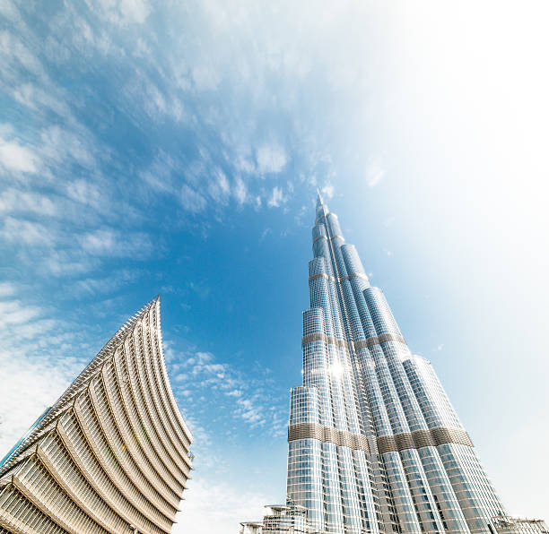 burj khalifa vanishing in blauen himmel. dubai, vae. - editorial tall luxury contemporary stock-fotos und bilder