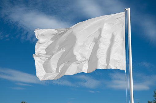 blank white flying flag on a clear sky 