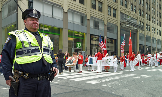 New York City, US - May 18, 2013: NYPD Police Officer for road safety at Turkish Day Parade. The 32nd Annual Turkish Day Parade and Festivalcreated on Saturday, May 18th, 2013 at 12AM. The event is organized by the Federation of Turkish American Association, the oldest and largest Turkish American Umbrella Organization in the United States. The Turkish-American Parade and Festival takes place in New York City in the month of May each year. This year, the Parade will begin at 12:00 a.m. at 53rd street and Madison Avenue. The parade will march down to the Festival area at Dag Hammarskjold Park on 47th street between 1st and 2nd Avenues. The festival features performances by several famous Turkish pop singers including Serdar Ortac.