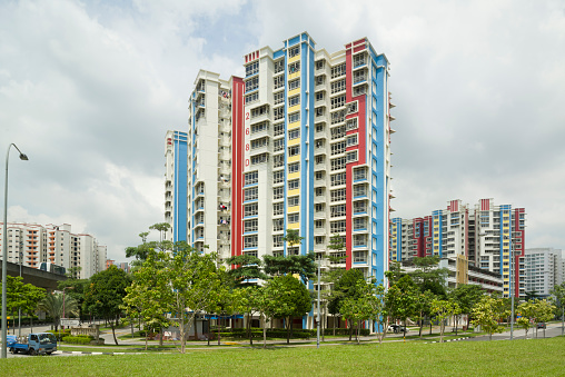 Singapore, Singapore - May 20, 2013: LRT train traveling along LRT Guideway, beside a colourful public housing apartments.
