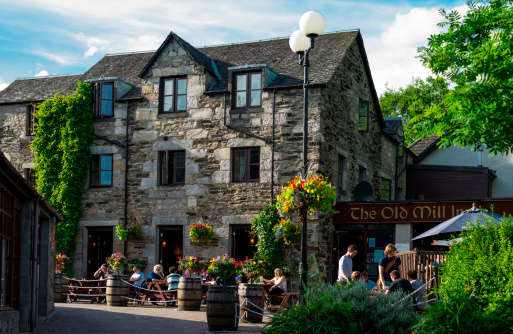 Pitlochry, United Kingdom - July 25, 2012: Customers takes the sun seated in the open air Old Mill restaurant, in the country center