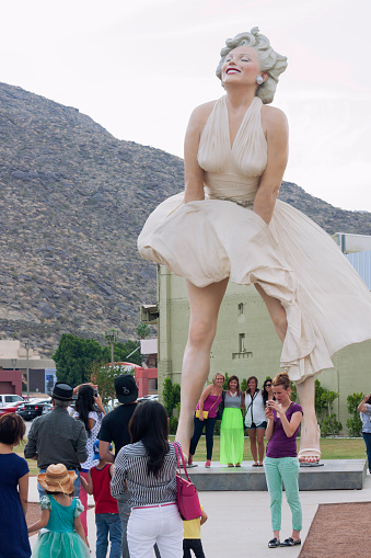 Palm Springs, California, USA - May 5, 2013: Tourists taking a picture by the Forever Marilyn statue from 2011, while others wait in line for their turn.
