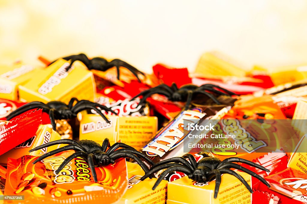 Chocolate Halloween Candy and Creepy Spiders Suffolk, Virginia, USA - October 1, 2012: A horizontal studio shot of an assortment of small American chocolate candies that are sold in stores around the country for Halloween. In the foreground are Milk Duds, Reese's Pieces, a Heath Bar and Rolo's. Creepy plastic spiders are placed on top of the candies. American Culture Stock Photo