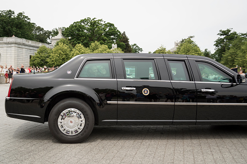 Arlington, VA, USA - May 27, 2013: President Obama leaves Arlington National Cemetery in the Presidential Limo while onlookers watch and wave.