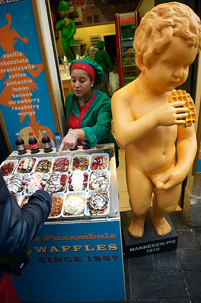 brüssel belgische waffel stand mit männeken pis peeing jungen - brussels waffle belgian waffle people stock-fotos und bilder