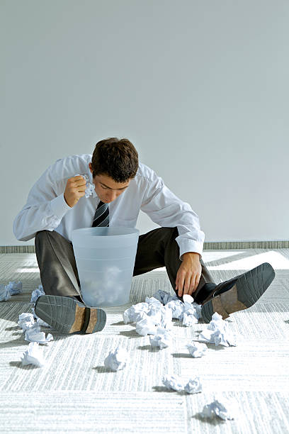istock young caucasian businessman seeking document in trash bin 471539704