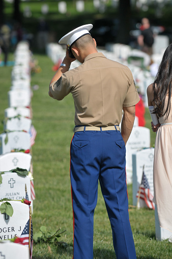 Arlington, Va. USA - May 27, 2013: A U.S. Marine Sergent visits a fallen comrade on Memorial Day at Arlington National Cemetery. 