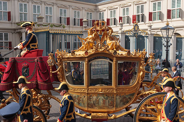 golden carriage arriving at noordeinde palace in the hague - prinsjesdag stockfoto's en -beelden