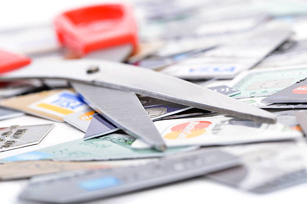 Scissor on pieces of credit cards Ankara, Turkey - October 17, 2012 : Studio shot of scissors on pieces of cutted three major credit cards Visa, MasterCard and American Express. american express stock pictures, royalty-free photos & images