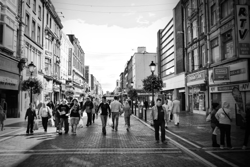 Dublin, Ireland - August 2, 2008: Street in Dublin black and white. People walking in a pedestrian area of Dublin full of shops during the day.