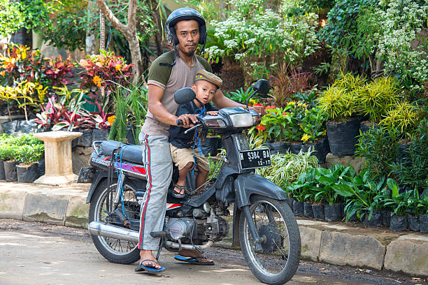 father and boy sitting on their motorbike - malang stockfoto's en -beelden