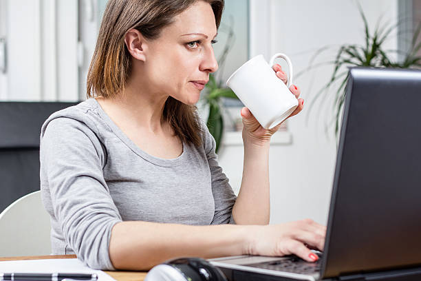 istock Photo of woman drinking coffee and doing work 471544356
