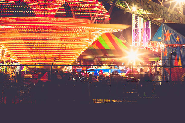 istock Summer carnival ride and bright lights at night 471544482