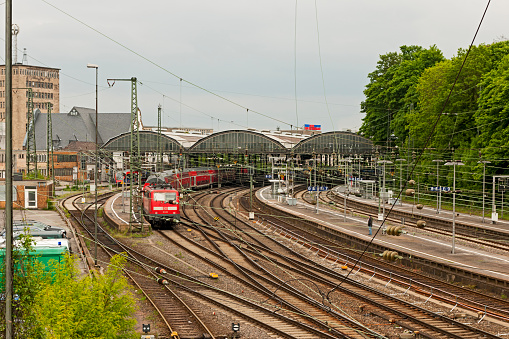 Burtscheid, Germany - May 20, 2013: View from the Burtscheider bridge to the station of Burtscheid. A train leaves the German Federal Railroad station and travels direction Cologne. On the platform, there are people waiting for their train. On the train the logos of DB (Deutsche Bahn). Deutsche Bahn AG is a national railway company in Germany and headquartered in Berlin.