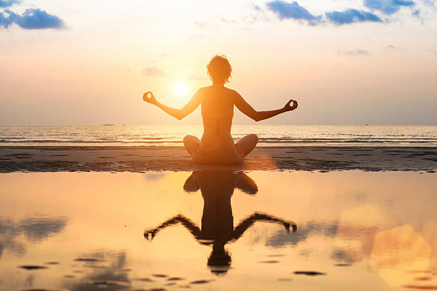 istock Woman practicing yoga on the beach at amazing sunset. 471546310