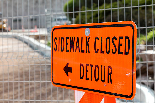 istock Orange sidewalk closed sign in front of sidewalk construction 471546424