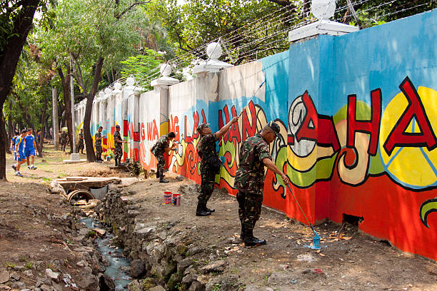 Soldiers painting in a wall Quezon City, Philippines - June 1, 2013: An attempt to make 3,770 meters of peace mural along the major national highway in Manila, which will be considered the longest peace mural in the world surpassing the Guinness record "Chile Wall of Peace" which is only 1,000 meters. The project " A journey of peace" was started May 26th, 2013 with several peace advocates groups including the Armed Forces of the Philippines. guinnes stock pictures, royalty-free photos & images