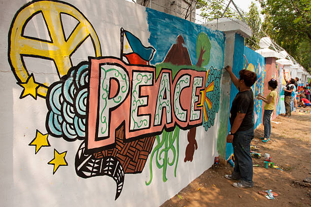 Painting peace in a wall Quezon City, Philippines - June 1, 2013: An attempt to make 3,770 meters of peace mural along the major national highway in Manila, which will be considered the longest peace mural in the world surpassing the Guinness record "Chile Wall of Peace" which is only 1,000 meters. The project " A journey of peace" was started May 26th, 2013 with several peace advocates groups including the Armed Forces of the Philippines. guinnes stock pictures, royalty-free photos & images