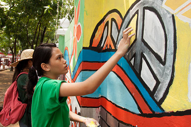 Hand painting for peace in a wall Quezon City, Philippines - June 1, 2013: An attempt to make 3,770 meters of peace mural along the major national highway in Manila, which will be considered the longest peace mural in the world surpassing the Guinness record "Chile Wall of Peace" which is only 1,000 meters. The project " A journey of peace" was started May 26th, 2013 with several peace advocates groups including the Armed Forces of the Philippines. guinnes stock pictures, royalty-free photos & images