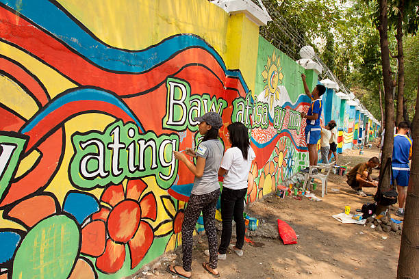 Volunteers painting the wall with peace mural Quezon City, Philippines - June 1, 2013: An attempt to make 3,770 meters of peace mural along the major national highway in Manila, which will be considered the longest peace mural in the world surpassing the Guinness record "Chile Wall of Peace" which is only 1,000 meters. The project " A journey of peace" was started May 26th, 2013 with several peace advocates groups including the Armed Forces of the Philippines. guinnes stock pictures, royalty-free photos & images