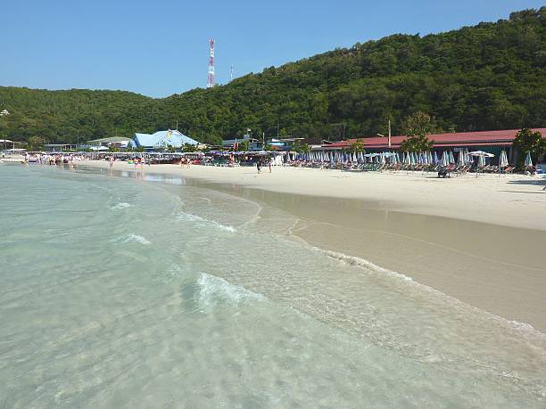Ko Larn, Thailand - December 2, 2011: Ko Larn island white sand beach. Tourists and locals enjoying swimming and sunbathing on the blue sea of this little island near Pattaya