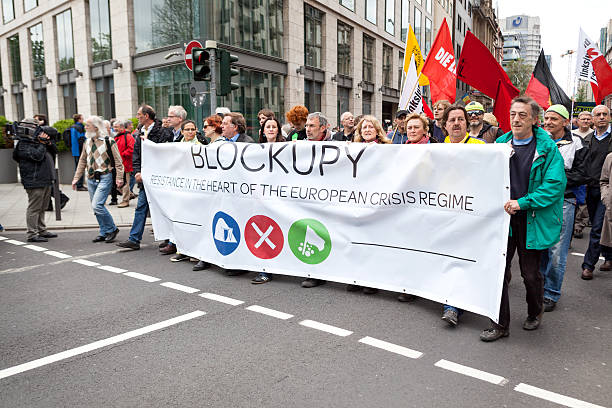 Protestors at Blockupy 2013 demonstration, Frankfurt Frankfurt, Germany - June 1, 2013: Protestors at Blockupy 2013 demonstration in the city center of Frankfurt holding up a banner. Blockupy is a left-wing political network of several organizations. The name derives from its plan for a "blockade" and the Occupy movement. protestors at blockupy 2013 demonstration frankfurt stock pictures, royalty-free photos & images