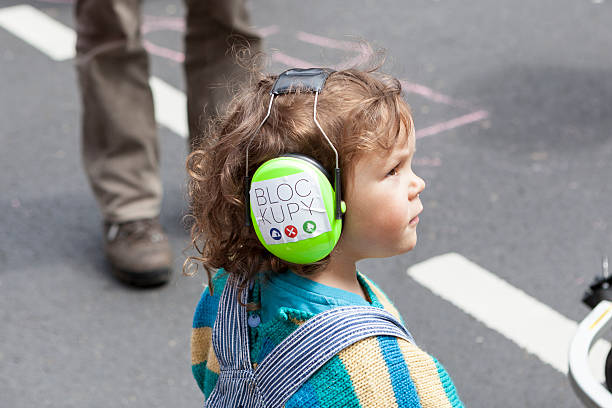 Blockupy 2013, Frankfurt Frankfurt, Germany - June 1, 2013: Protestors at Blockupy 2013 demonstration in the city center of Frankfurt. A little girl is wearing protective ear muffs with a blockupy sticker. Blockupy is a left-wing political network of several organizations. The name derives from its plan for a "blockade" and the Occupy movement. protestors at blockupy 2013 demonstration frankfurt stock pictures, royalty-free photos & images
