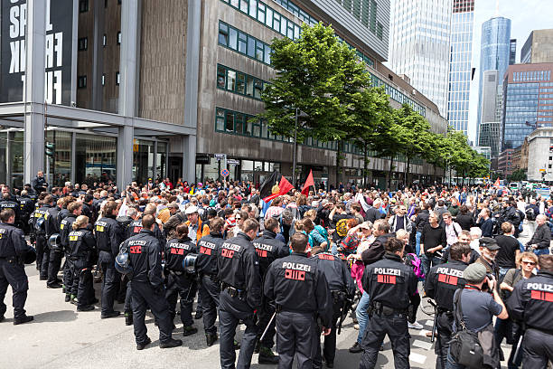 Blockupy 2013, Frankfurt Frankfurt, Germany - June 1, 2013: Protestors and anti-riot police standing face to face at Blockupy 2013 demonstration in the city center of Frankfurt. Blockupy is a left-wing political network of several organizations. The name derives from its plan for a "blockade" and the Occupy movement. protestors at blockupy 2013 demonstration frankfurt stock pictures, royalty-free photos & images