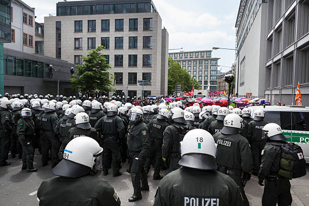Blockupy 2013, Frankfurt Frankfurt, Germany - June 1, 2013: Protestors (in the background) and anti-riot police standing face to face at Blockupy 2013 demonstration in the city center of Frankfurt. Blockupy is a left-wing political network of several organizations. The name derives from its plan for a "blockade" and the Occupy movement. protestors at blockupy 2013 demonstration frankfurt stock pictures, royalty-free photos & images