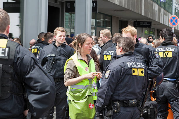 Blockupy 2013, Frankfurt Frankfurt, Germany - June 1, 2013: Blockupy 2013 demonstration. A female member of German Bundestag (Bundestagsabgeordnete of german party "Die Linke") tries to mediate between riot police and protestors in the city center of Frankfurt. Blockupy is a left-wing political network of several organizations. The name derives from its plan for a "blockade" and the Occupy movement. protestors at blockupy 2013 demonstration frankfurt stock pictures, royalty-free photos & images