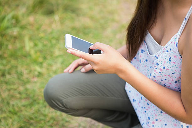 istock Pretty brunette texting in the park 471548810