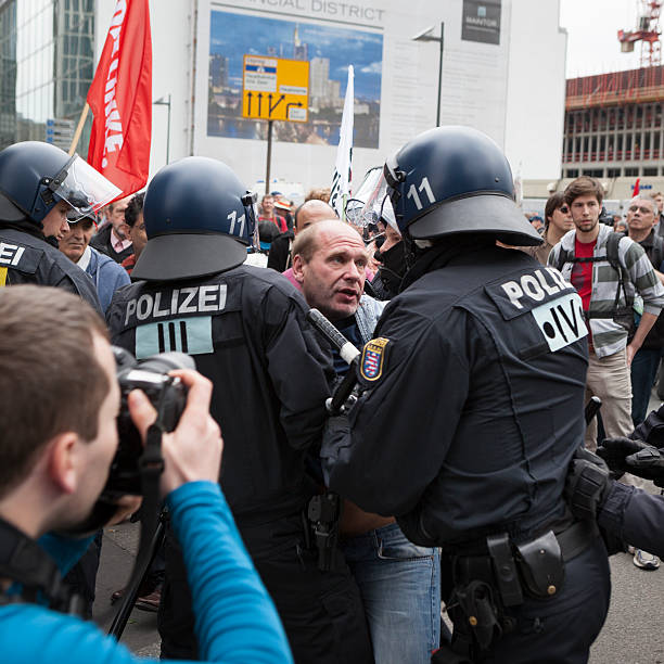 Blockupy 2013, Frankfurt Frankfurt, Germany - June 1, 2013: A male protestor is trying to break through the riot police cordon - and getting into a fight at Blockupy 2013 demonstration in the city center of Frankfurt. Blockupy is a left-wing political network of several organizations. The name derives from its plan for a "blockade" and the Occupy movement. protestors at blockupy 2013 demonstration frankfurt stock pictures, royalty-free photos & images