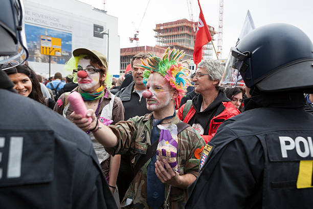 Blockupy demonstration 2013, Frankfurt Frankfurt, Germany - June 1, 2013: Participants of Blockupy 2013 demonstration - disguised as clowns - trying to start a funny discussion with riot police in the city center of Frankfurt. Blockupy is a left-wing political network of several organizations. The name derives from its plan for a "blockade" and the Occupy movement. protestors at blockupy 2013 demonstration frankfurt stock pictures, royalty-free photos & images