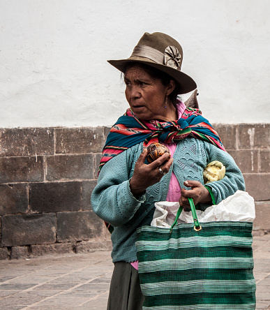 Cuzco, Peru - March 8, 2013: A Quechua woman sells hand carved gourds in the main square Plaza de Armas in Cuzco, Peru. 