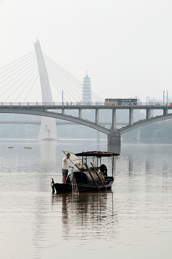 Jiangxi, China - March 10, 2013: Colour photograph of a local Hakka fisherman, fishing in the Gan river 